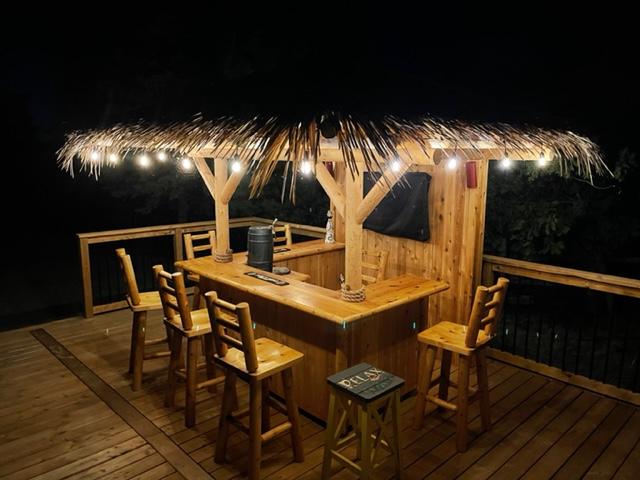 Thatched tiki bar next to a backyard pool